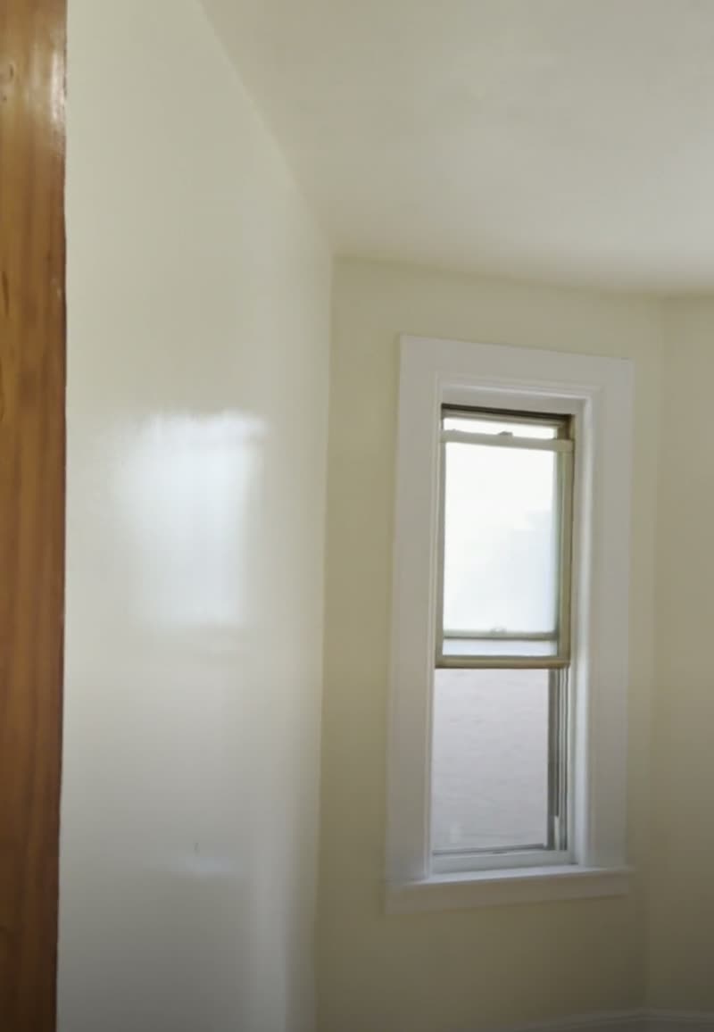 After: the same window finished with a brand-new white casing, a smooth new ceiling and fresh paint